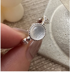 Close-up of S925 sterling silver ring with moonstone and vintage beaded band on finger