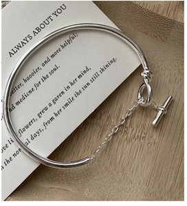 Macro shot of S925 sterling silver bangle with OT buckle on wooden background
