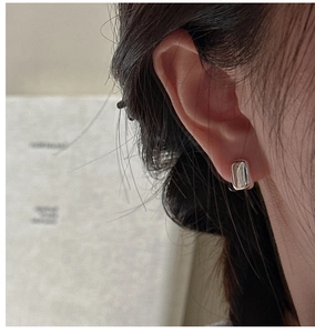 Gros plan de boucles d'oreilles rectangulaires en argent avec texture martelée