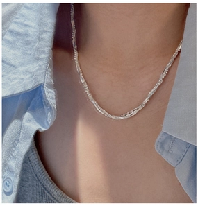 Gros plan d'un collier multicouche en argent 925 avec perles et chaîne serpent plate