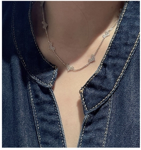 Detailed view of S925 sterling silver necklace with textured heart pendants on a model