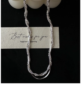 Détail d'un collier chaîne à corde torsadée en argent sterling S925 sur fond noir