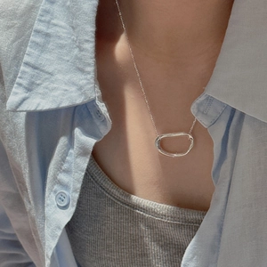 Minimalist S925 sterling silver oval pendant necklace worn on a striped shirt