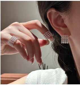 Dettaglio del set di gioielli in argento S925 con anelli e clip a griglia dal design moderno