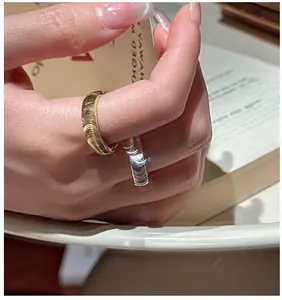 Macro detail of wide gold ring with horizontal textured wave engraving on the band