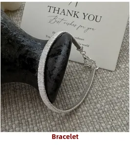 Close-up of woven S925 sterling silver bracelet with lobster clasp on a rustic vase
