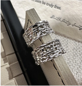Macro detail of 925 sterling silver rings with intricate cutout organic lava texture