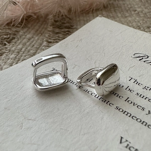 Créoles carrées en argent sterling S925 poli présentées sur un fond minimaliste chic