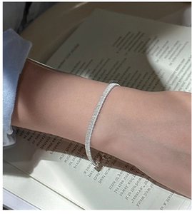 Macro shot of silver woven texture bracelet with adjustable chain on model's wrist