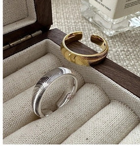 Detailed view of adjustable gold and silver rings with fine horizontal ribbing texture