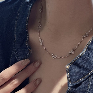 Elegant rose gold S925 silver necklace with textured heart pendants on a denim jacket