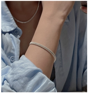 Detail of S925 sterling silver woven texture bracelet worn with light blue linen shirt