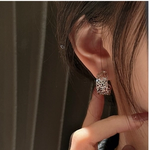 Detailed close-up of 925 silver C-shape hoop earrings with vintage lava texture on ear