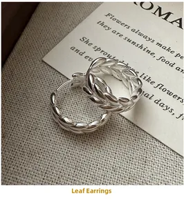 Detailed macro view of S925 sterling silver wheat ear pattern earrings on linen
