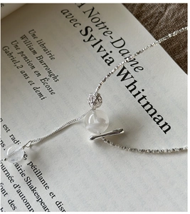 Detail of S925 silver necklace with translucent beads on a vintage French book