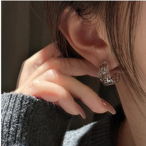 Macro shot of 925 sterling silver C-shaped mesh earrings with fine CNC cut texture