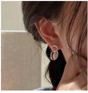 Macro detail of S925 silver double hoop earrings with a baroque pearl drop on ear