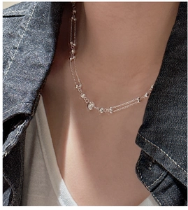 Close-up of double-layer S925 silver beaded necklace worn on neck with denim jacket