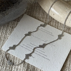 Minimalist S925 sterling silver necklace with textured heart pendants on poetic background