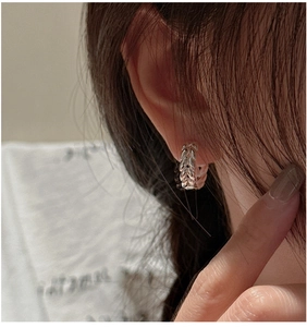 Macro detail of S925 sterling silver hoop earrings with wheat ear textured pattern