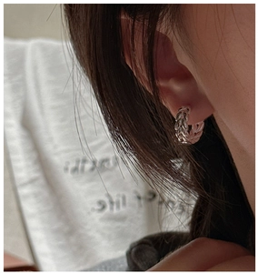 Detail of S925 sterling silver hoop earrings with a braided wheat chain texture pattern