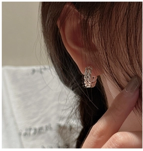Close-up of S925 sterling silver hoop earring with textured wheat ear pattern on model