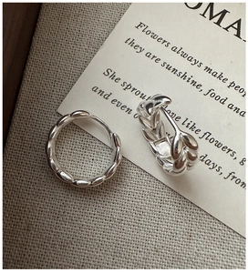 Close-up of S925 sterling silver wheat ear hoop earrings on artistic fabric background