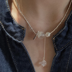 S925 sterling silver snowflake ghost necklace with shimmering chain on a denim collar