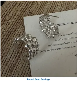 Dettaglio di orecchini a cerchio a C in argento 925 con perline su sfondo rustico