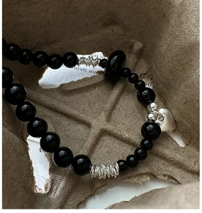 Detailed view of S925 silver beaded bracelet with black agate beads and a heart charm