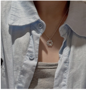Primo piano della collana con ciondolo ad anello intrecciato in argento S925 su modella