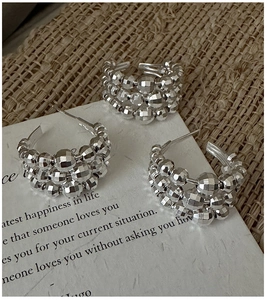 Detail of S925 sterling silver beaded earrings with faceted metallic surface texture