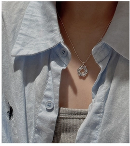 Dettaglio della collana con ciondolo croissant in argento S925 indossata per look elegante