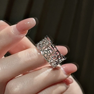 Macro shot of the geometric hollow lattice pattern on a wide silver band ring