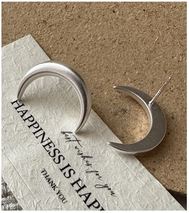 Macro view of S925 sterling silver matte moon earrings with clear hallmark engraving
