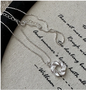 Macro della collana con ciondolo a croissant in argento S925 su sfondo di lino letterario
