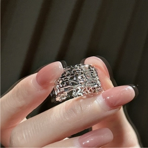 Macro detail of silver geometric镂空 ring with CNC faceted design on hand