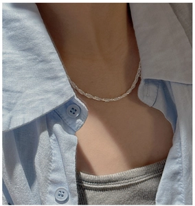 Detail of S925 sterling silver twist chain necklace worn by a model in casual attire