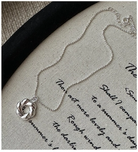 Dettaglio della collana croissant in argento sterling S925 con ciondolo intrecciato e marchio