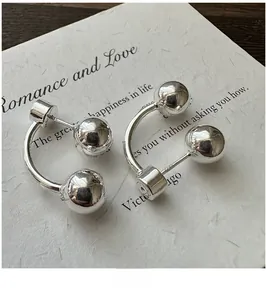 Detail of S925 sterling silver ball earring with high-polish finish on a poetic card