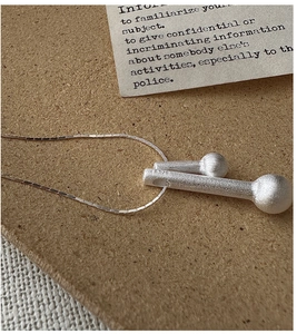Vue macro d'un pendentif allumette en argent S925 avec texture brossée mate