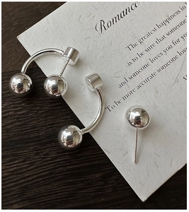 Close-up of S925 sterling silver ball earrings with C-shaped curved design and polished finish