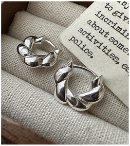 Close-up of twisted S925 sterling silver hoop earrings in a minimalist jewelry box
