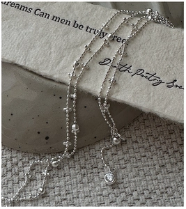 Detailed macro view of S925 silver beaded necklace featuring a zircon pendant and cross elements