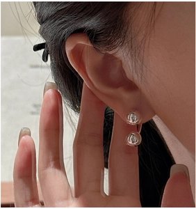 Macro shot of silver ball earrings featuring high-polish finish and unique back-hang design