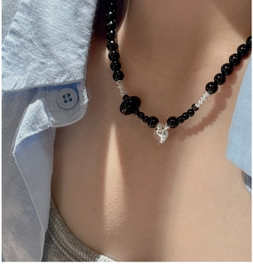 Detail of beaded necklace with black onyx beads and heart shaped silver pendant