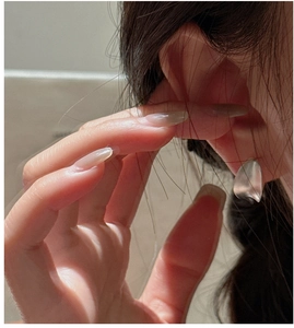 Close-up of 925 sterling silver C-shaped earring with matte finish on a model's ear