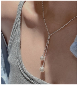 Silver S925 Y-shaped tassel necklace with elegant white pearls on a model neck