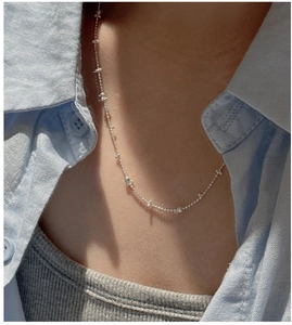 Detail of a S925 sterling silver minimalist bead chain necklace on a model's neck