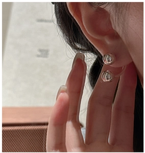 Detail of silver S925 beaded earrings showing high-shine finish and U-shaped hook design